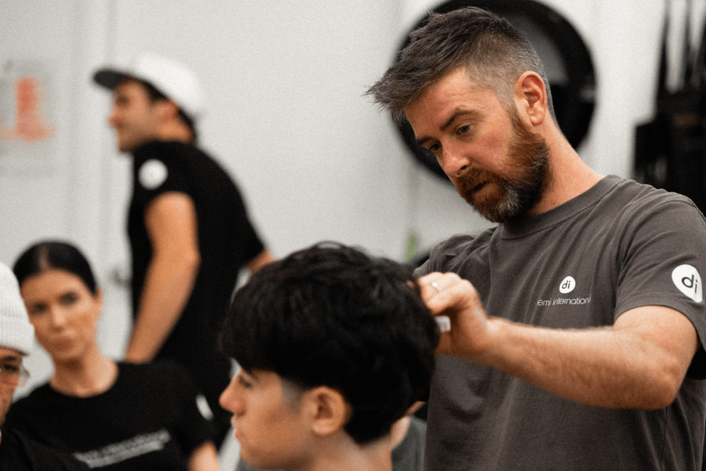 Demi International trainer demonstrating to students how to cut men's hair